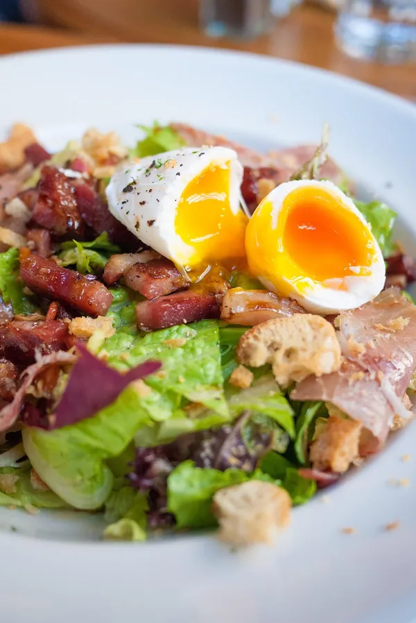 Brunch-Salat mit pochiertem Ei, Speck, Schinken und Croûtons