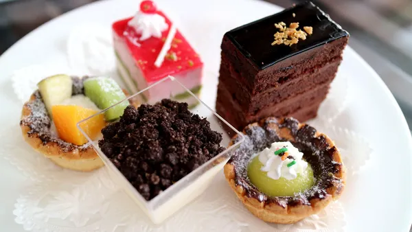 Kleine Dessert-Auswahl und Tartelettes auf weißem Teller